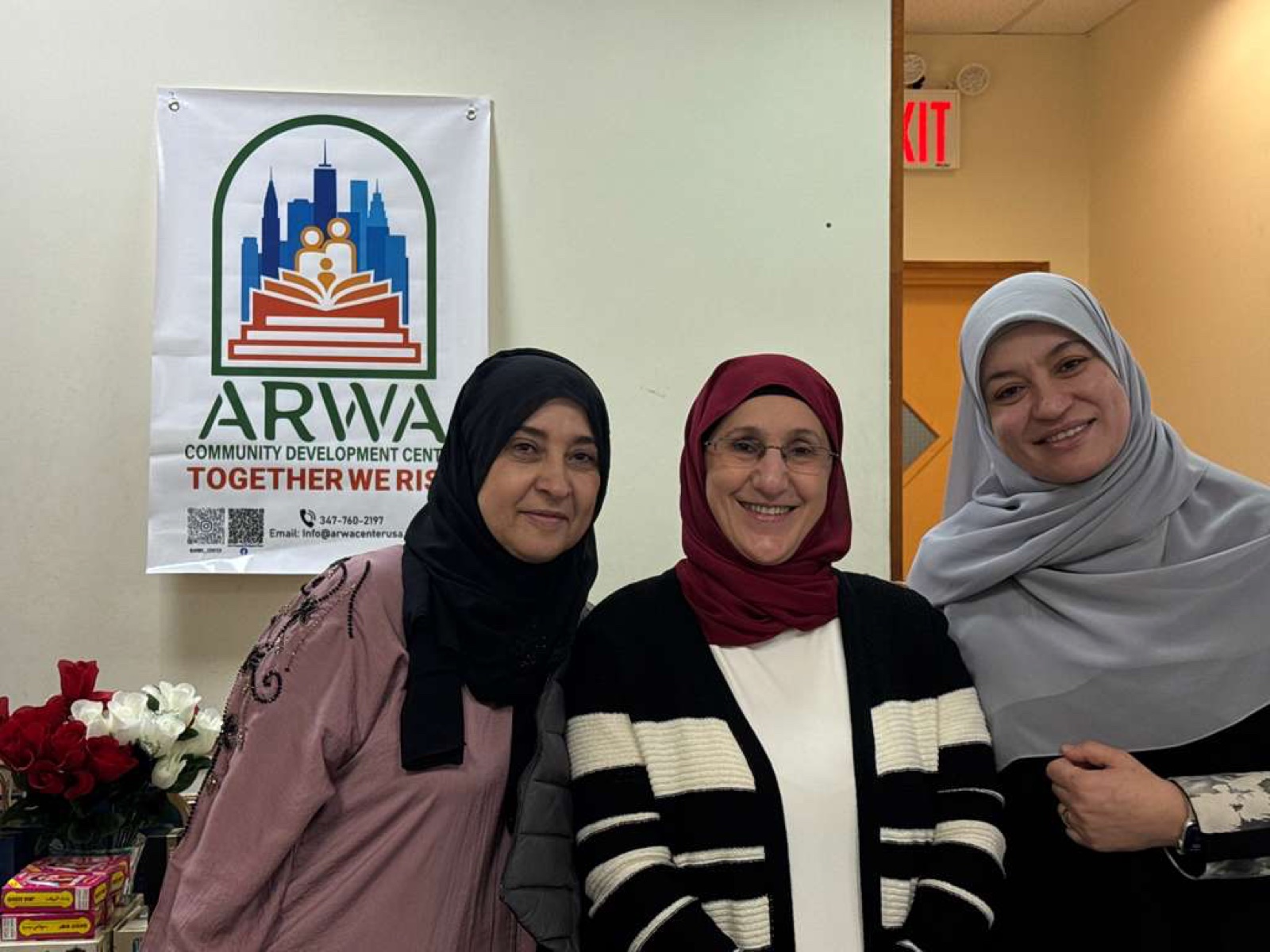 ARWA volunteers in front of the ARWA Community Development Center Together We Rise banner